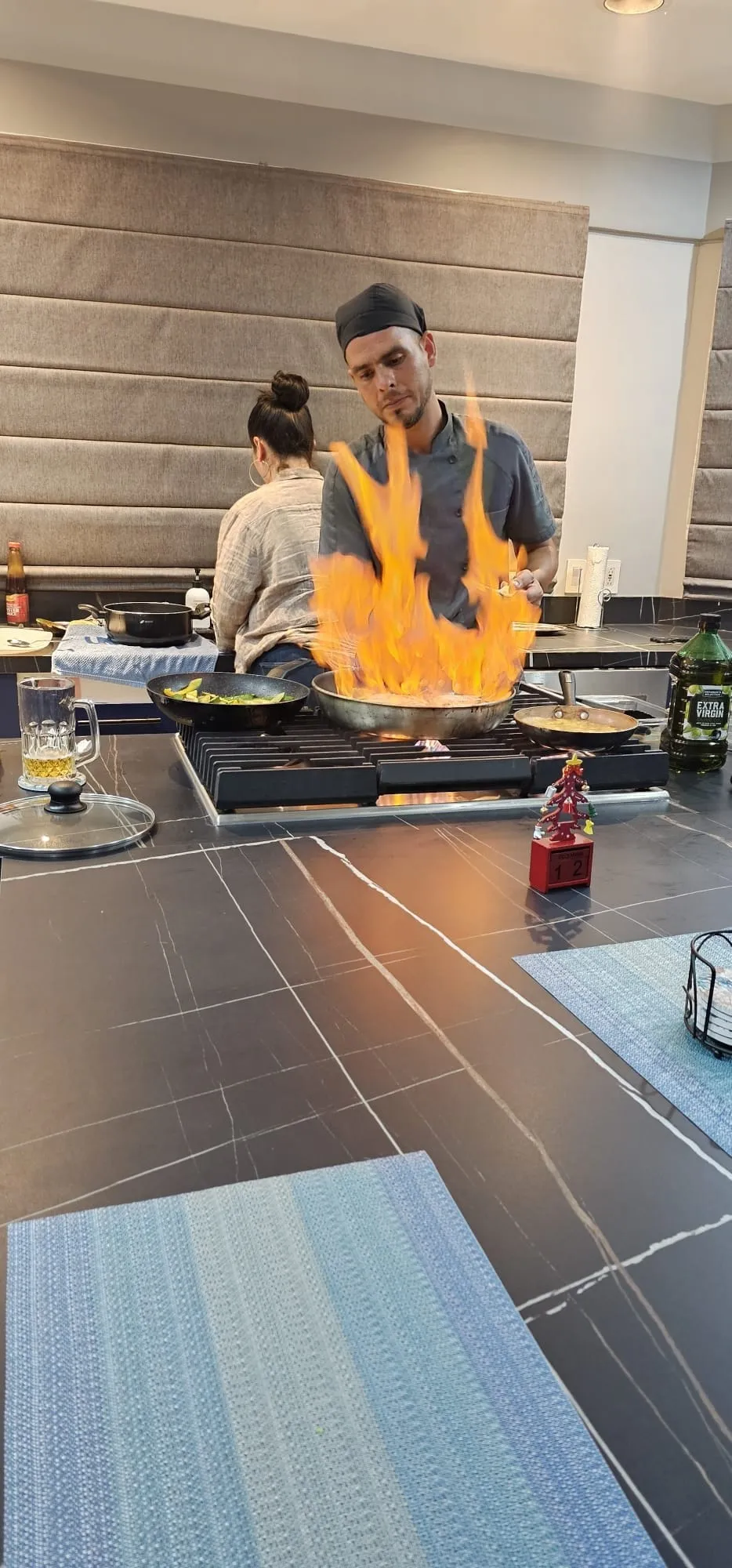 Private chef flambéing a dish on the kitchen island during an all-inclusive dinner