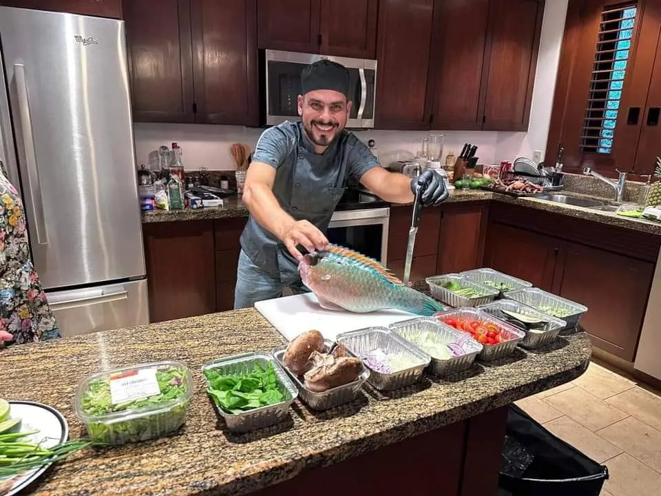 The villa chef filleting a freshly caught fish in the kitchen