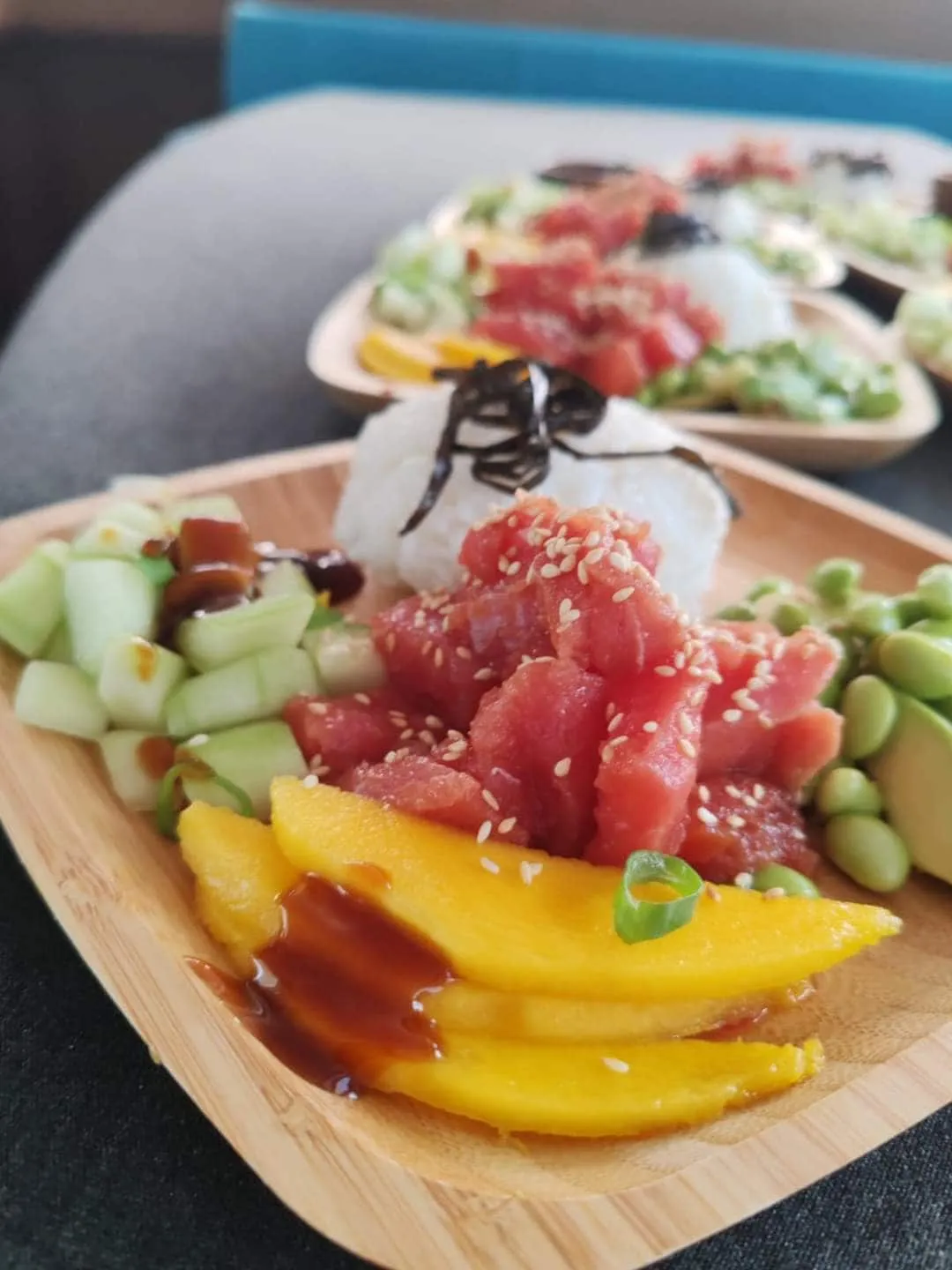 Tuna poke with mango, cucumber, and sesame on a wooden board