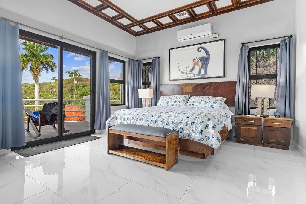 Bedroom 1 with king bed, wood furniture, air conditioning, and doors opening onto the terrace