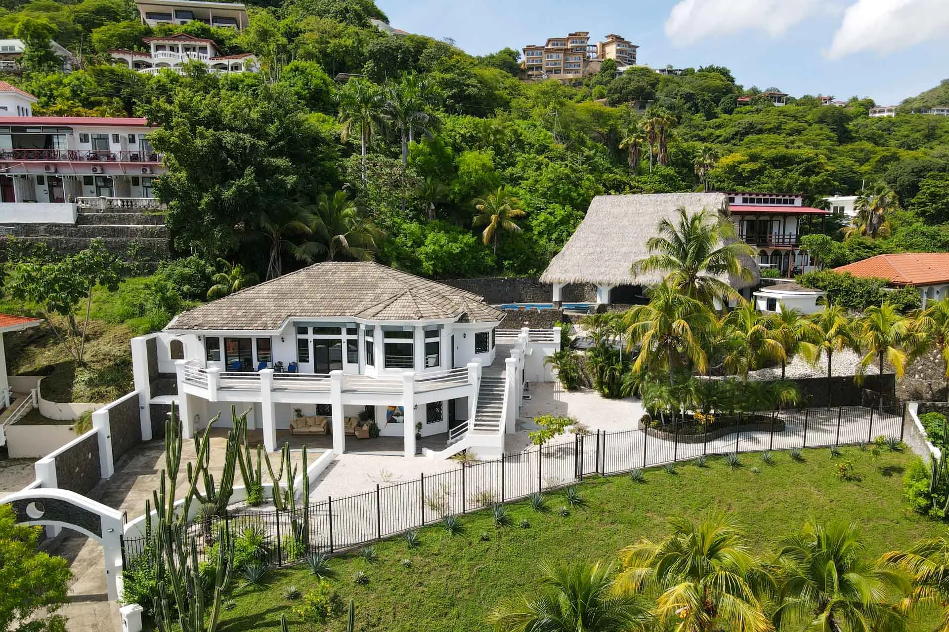 Aerial view of the white villa, rancho, pool, and lawn on the Ocotal hillside